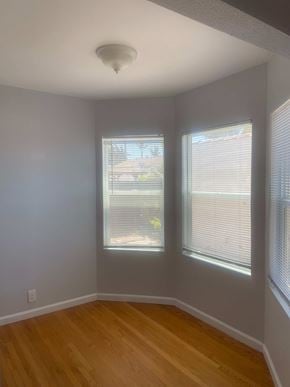 Santa Maria house for rent - A room with wooden floors and two windows with blinds.