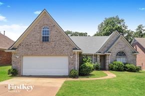 Memphis house for rent - a brick house with a white garage door and a lawn