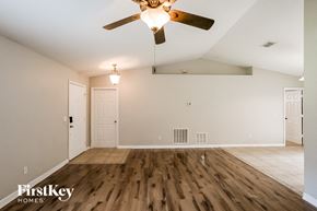 Orange City house for rent - A room with a ceiling fan and wooden floors.