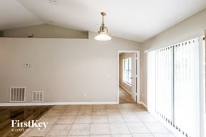 Orange City house for rent - A room with a light fixture and a doorway leading to another room.