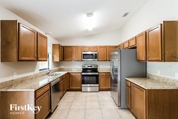 Orange City house for rent - A kitchen with wooden cabinets and stainless steel appliances.