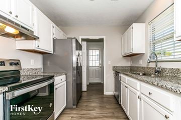 High Point house for rent - A kitchen with white cabinets and a granite countertop.