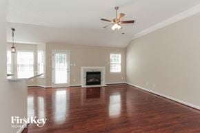 Charlotte house for rent - A spacious room with a fireplace and a ceiling fan.