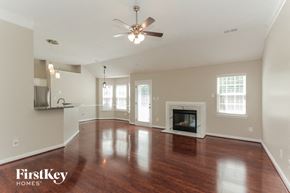 Charlotte house for rent - A spacious living room with wood floors and a fireplace.