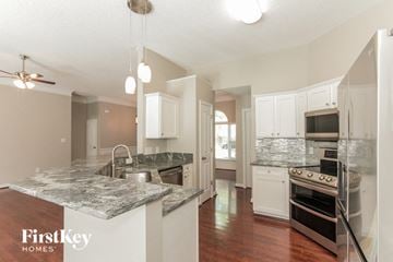 Charlotte house for rent - A kitchen with a marble countertop and a stove top oven.