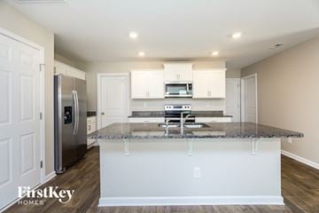 Dallas house for rent - a kitchen with white cabinets and a granite counter top