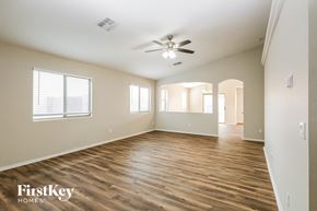 Phoenix house for rent - A spacious room with wooden floors and a ceiling fan.
