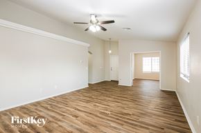 Phoenix house for rent - A spacious room with wooden floors and a ceiling fan.
