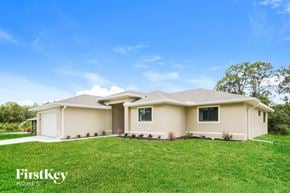 Lehigh Acres house for rent - a beige house with a lawn in front of it
