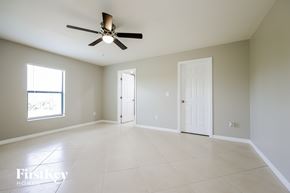 Lehigh Acres house for rent - A spacious room with a ceiling fan and tile flooring.