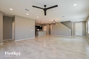 Tucson house for rent - A spacious room with a ceiling fan and a chandelier.