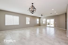 Tucson house for rent - A spacious room with a chandelier and a ceiling fan.