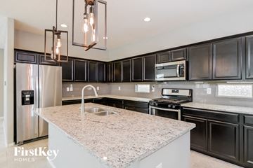 Tucson house for rent - A modern kitchen with a granite countertop and stainless steel appliances.