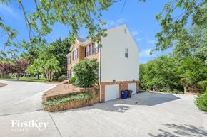 Winston-Salem house for rent - a white and brick house with a garage and a driveway