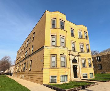 Chicago apartment for rent - A yellow building with a black door and windows.