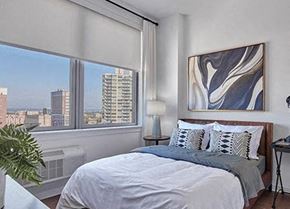 New Brunswick apartment for rent - A bedroom with a large bed and a view of the city.