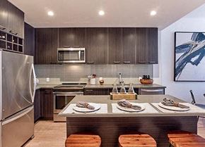 New Brunswick apartment for rent - A modern kitchen with a stainless steel refrigerator and wooden bar stools.