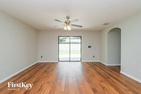 Riverview house for rent - an empty living room with wood floors and a ceiling fan