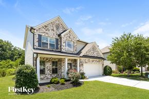 Cumming house for rent - a brick house with a white garage door and a lawn