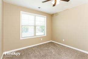 Cumming house for rent - a bedroom with carpet and a window and a ceiling fan