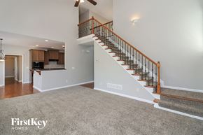 Dallas house for rent - A spacious living room with a staircase leading to the upper floor.