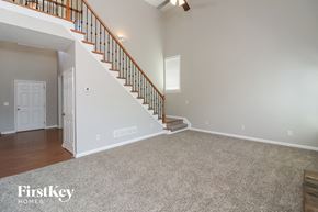 Dallas house for rent - A spacious room with a staircase and a carpeted floor.