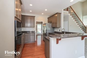 Dallas house for rent - A kitchen with a stainless steel refrigerator and wooden cabinets.