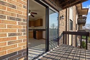 Naperville apartment for rent - A balcony with a glass door leading to a kitchen.