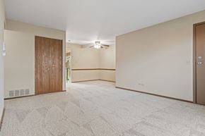 Naperville apartment for rent - A spacious room with a carpeted floor and a ceiling fan.