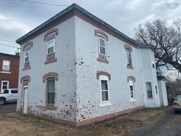 Stellarton apartment for rent - an old white brick building with white paint and red bricks