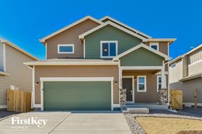 Colorado Springs house for rent - a green and brown house with a garage door