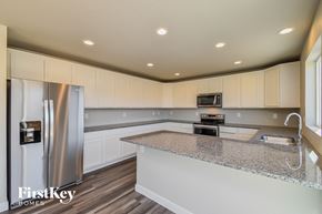 Colorado Springs house for rent - a kitchen with white cabinets and a granite counter top