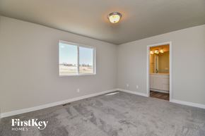 Colorado Springs house for rent - a bedroom with a carpeted floor and a large window