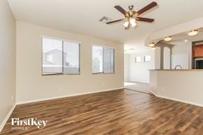 Phoenix house for rent - an empty living room with a ceiling fan and a kitchen