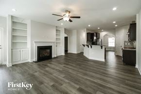 Colfax house for rent - A spacious living room with a fireplace and a ceiling fan.