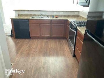Colorado Springs house for rent - a kitchen with wooden floors and a stove and a sink