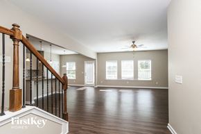 Canton house for rent - A spacious room with wooden floors and a staircase leading to the upper level.
