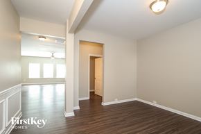 Canton house for rent - A spacious room with wooden floors and white walls, with a doorway leading to another room.