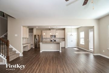 Canton house for rent - A spacious kitchen and living room with wood flooring and a staircase on the left.