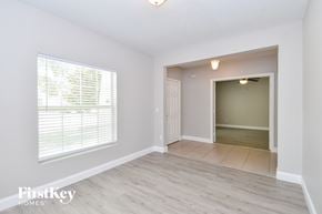 Apopka house for rent - a living room with a large window and a door to a hallway
