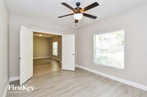 Apopka house for rent - a living room with a ceiling fan and a door to a hallway