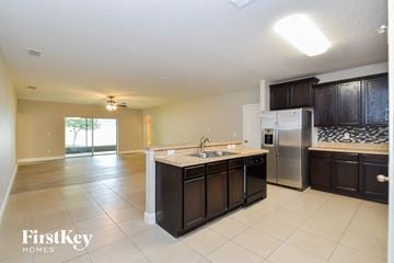 Apopka house for rent - a kitchen with an island and a stainless steel refrigerator