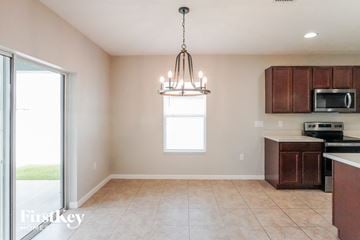 Davenport house for rent - a kitchen with wooden cabinets and a chandelier
