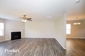 Gastonia house for rent - A spacious living room with a fireplace and wood flooring.