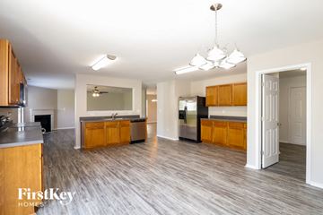 Gastonia house for rent - A spacious kitchen with wooden cabinets and a grey countertop.