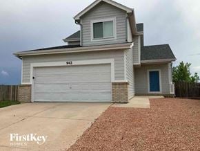 Fountain house for rent - a white house with a white garage door and a gravel driveway