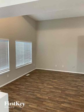 Fountain house for rent - an empty living room with wood flooring and two windows