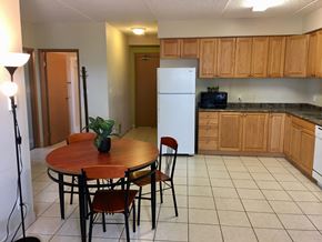 Waterloo apartment for rent - a kitchen with wooden cabinets and a table and a refrigerator