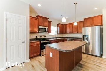 Raleigh house for rent - a kitchen with wooden cabinets and stainless steel appliances