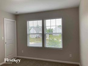 Lowell house for rent - a living room with two windows and a white door
